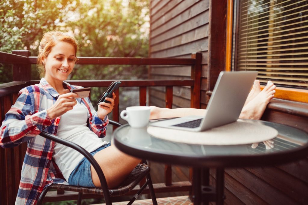 girl holding her phone and credit card to purchase online